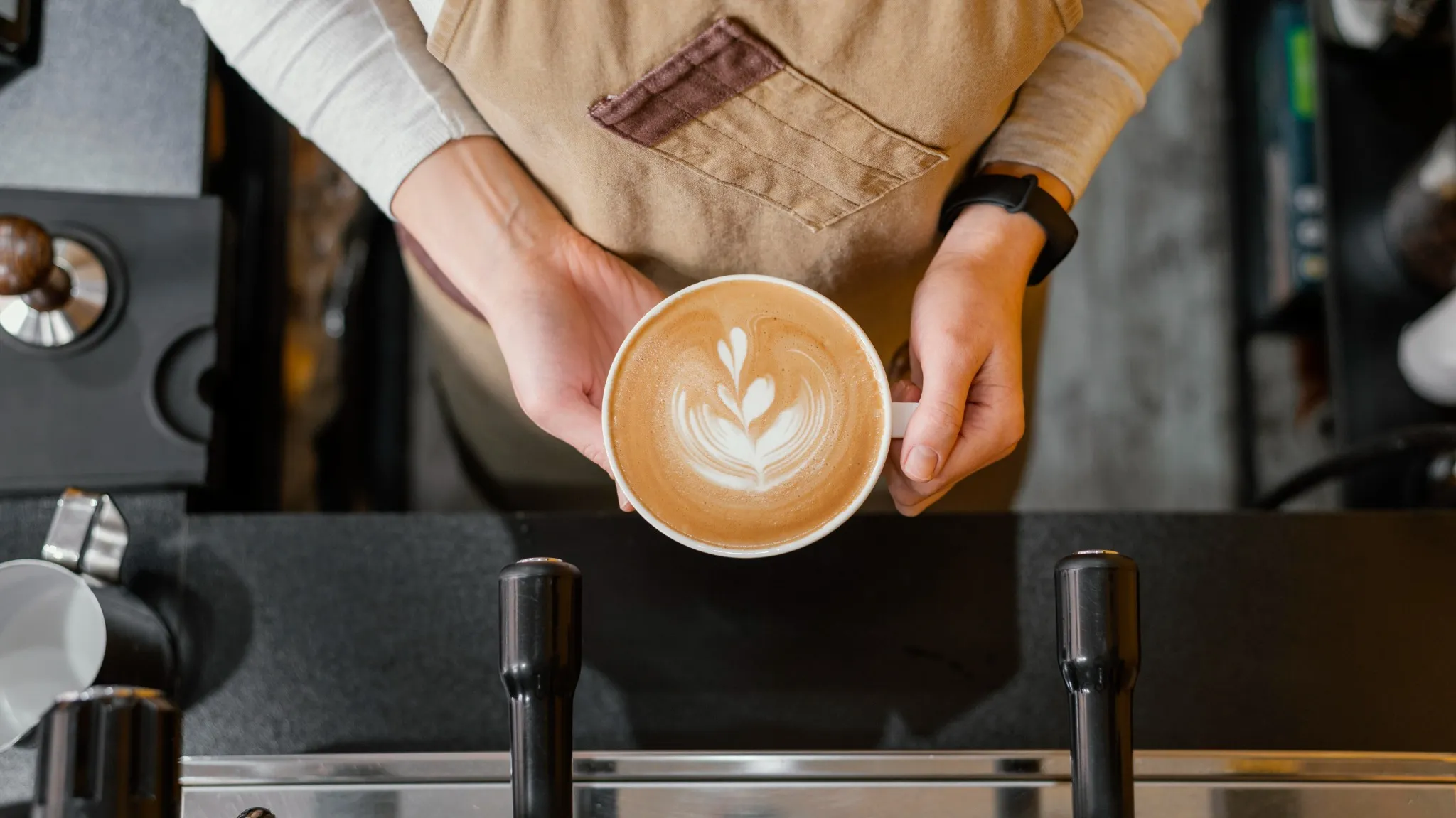 Barista che tiene una tazza con latte art