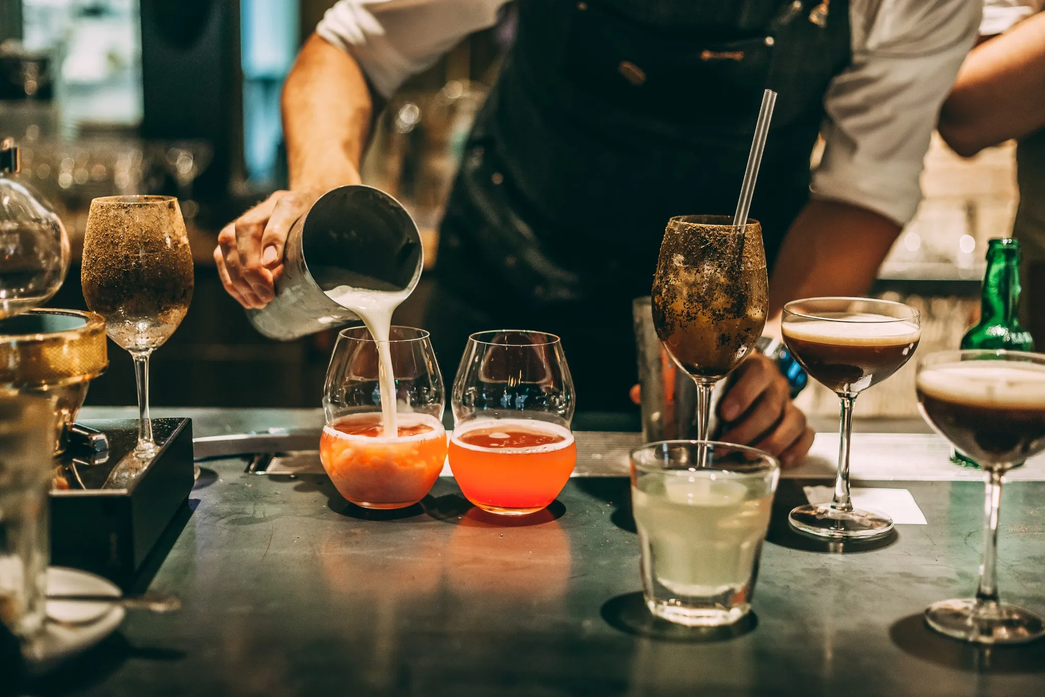 Barman che versa un cocktail estivo in un bicchiere