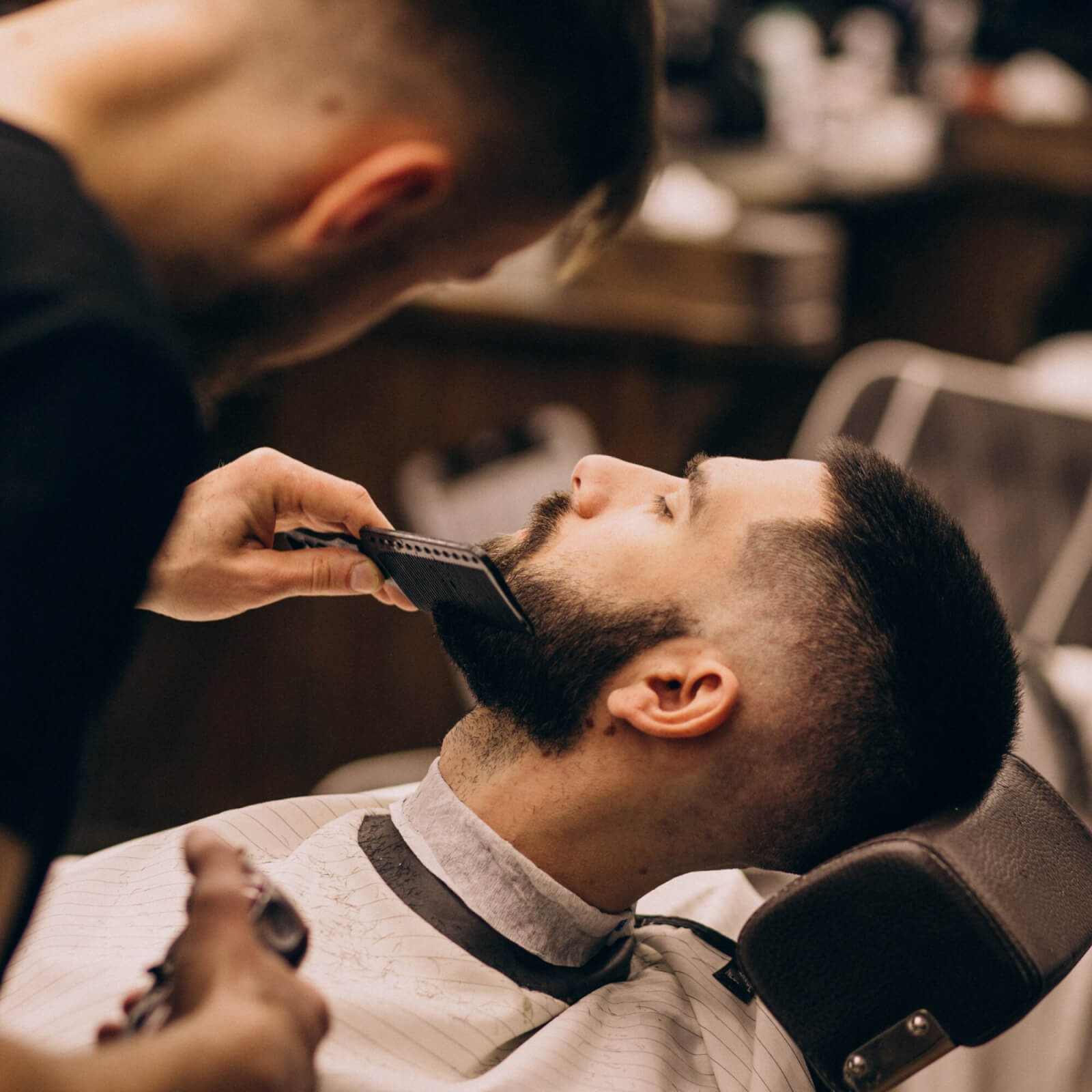 Photo of a barber shaving a customer's beard to describe Barber Shop Music