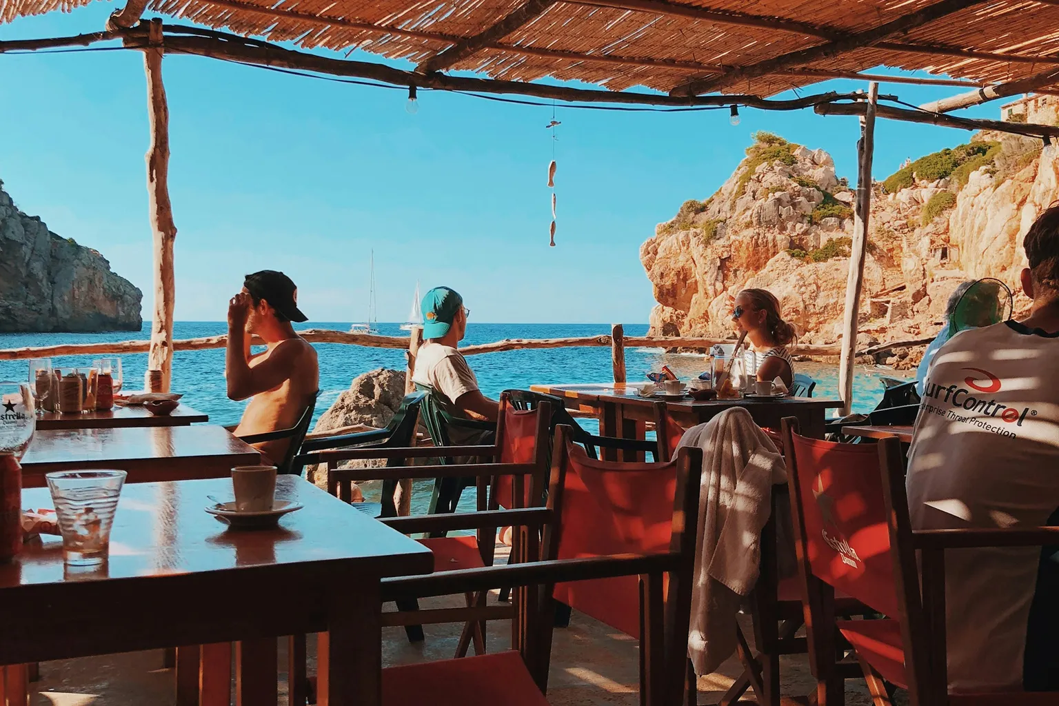 Persone sedute a un beach club con vista mare